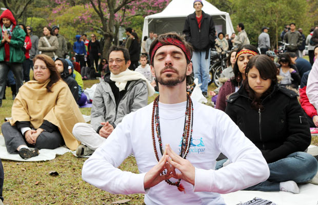Legenda: Pessoas meditam em evento de ioga pela paz no Ibirapuera