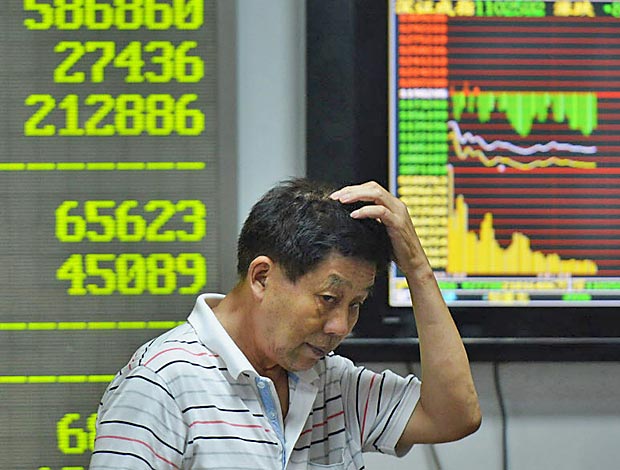 An investor gestures in front of screens showing share prices at a securities firm in Hangzhou, in eastern China's Zhejiang province on August 24, 2015. Shanghai shares nosedived 8.49 percent on August 24 as Beijing's latest market intervention failed to restore confidence, with concern mounting about the stalling economy. CHINA OUT -- AFP PHOTO ORG XMIT: WH4234