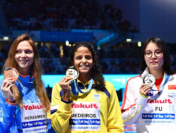 Etiene Medeiros (no centro) mostra a medalha de ouro na prova dos 50 m costas