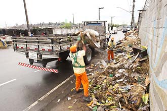 Funcionrio da prefeitura retira lixo acumulado em avenida