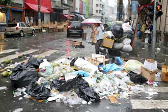 Lixo acumulado em esquina da principal rua de comrcio popular de So Paulo; lojiastas reclama da sujeira