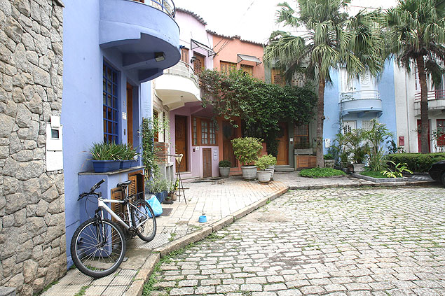 Bicicleta fica do lado de fora de casa em vila em Pinheiros