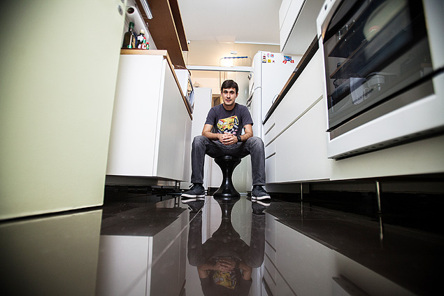 O auxiliar Jean Rodrigues, 30, em sua cozinha revestida com porcelanato preto brilhante