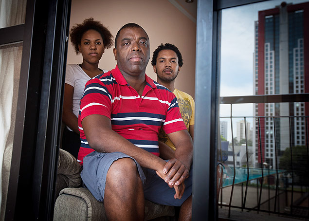 O analista de sistemas Marco Antônio Oliveira da Silva e seus filhos Nayara e Paulo, no apartamento onde moram 