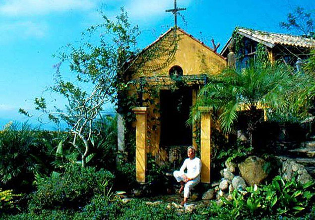 O estilista Clodovil Hernandes em frente à capela em sua propriedade