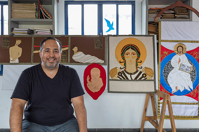 Jandir Leite Moreira, 44, com seus painis de arte sacra ao fundo