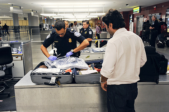 Agente inspeciona bagagem no aeroporto internacional John F. Kennedy, em Nova York (EUA)