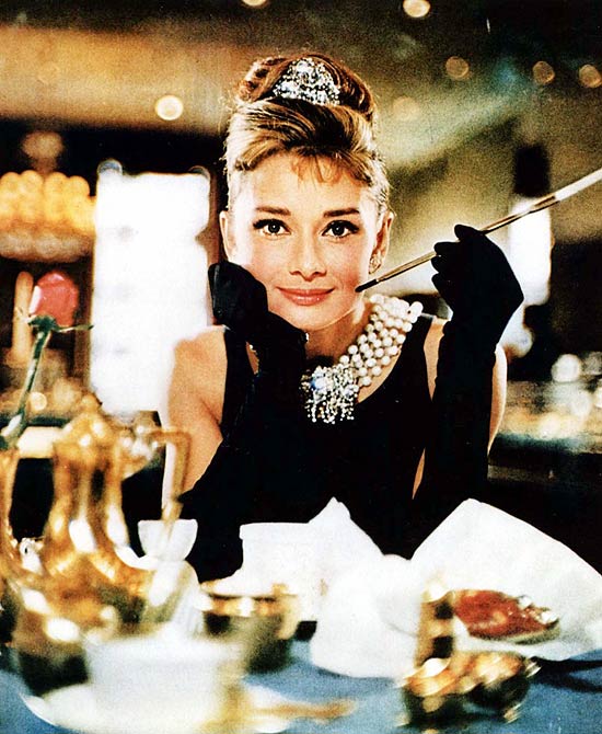 Audrey Hepburn caracterizada como Holly Golightly, protagonista de "Bonequinha de Luxo" (1961), filme em que canta "Moon River"