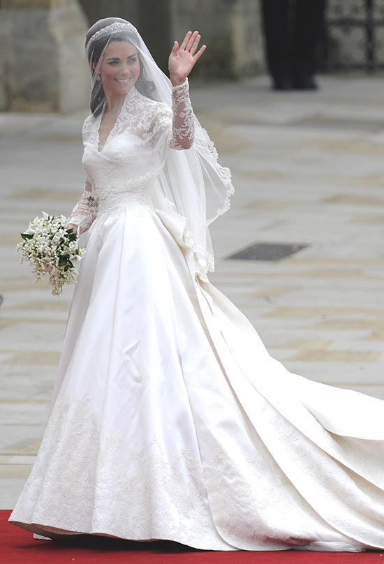 Kate Middleton acena para o público ao chegar na Abadia de Westminster no dia de seu casamento com o príncipe William