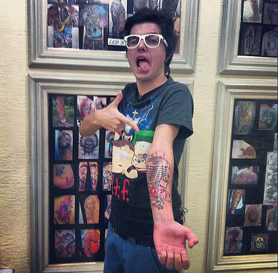 O cantor Pe Lanza, da banda Restart, mostra a tatuagem que fez no braço direito