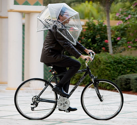 Ciclista anda com guarda-chuva que não vira com vendo e libera as mãos