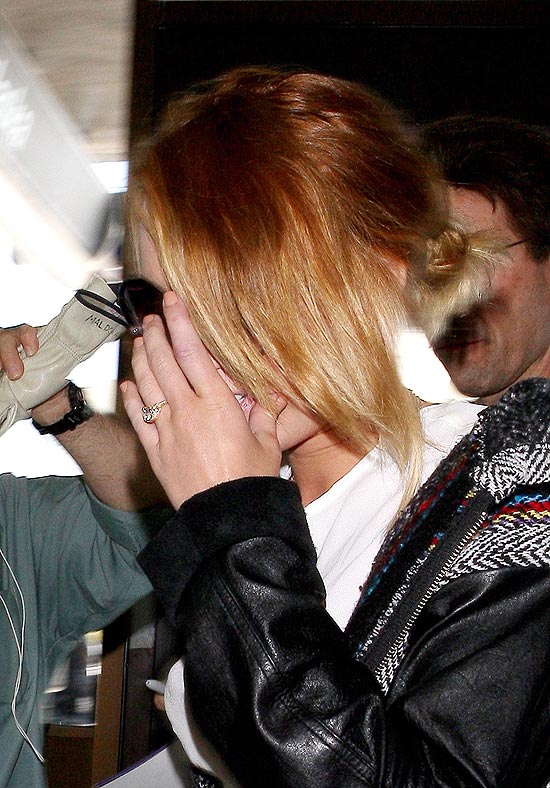 Miley Cyrus esconde o rosto, mas acaba exibindo o anel de noivado