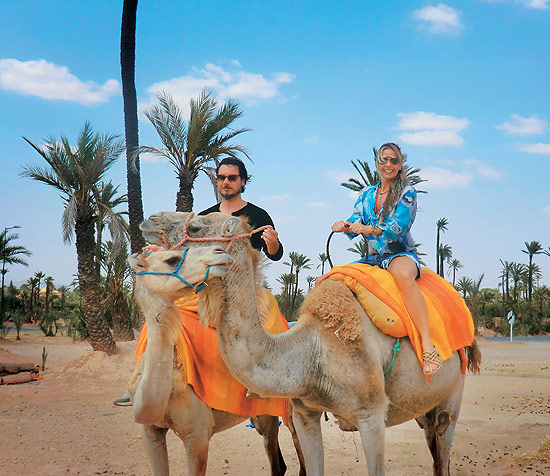 A apresentadora Adriane Galisteu passeia de camelo com o marido Alexandre Iódice no Marrocos