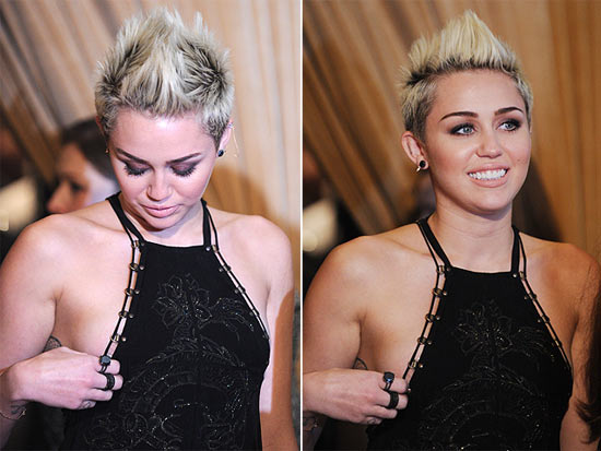 Miley Cyrus tenta ajeitar o vestido