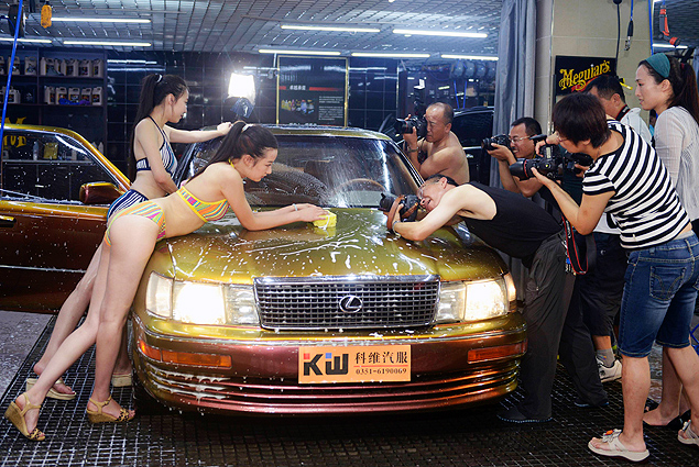 Dono de lava-rápido na China contrata modelos para lavarem carros e convida clientes a fotografá-las