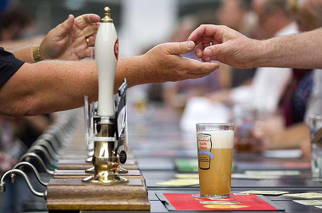 Homem paga por cerveja em festival em Londres; alto consumo de bebida alcoólica é um problema no Reino Unido