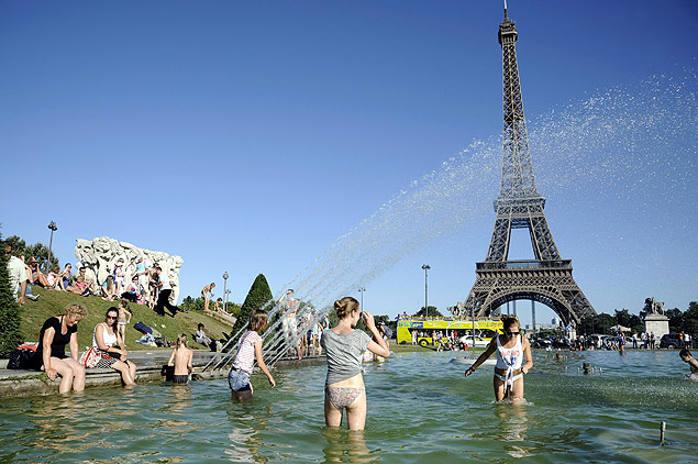 Pessoas se refrescam em fonte na frente da Torre Eiffel, em Paris