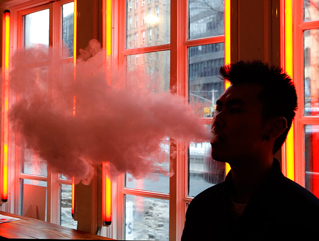 A man exhales vapor from an e-cigarette 