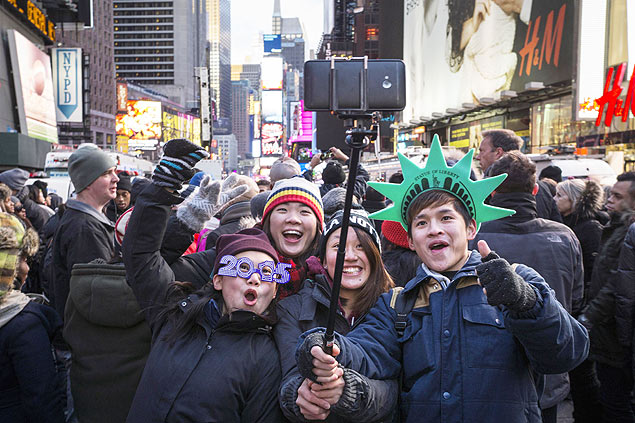 Turistas tiram foto com "pau de selfie" durante ano Novo na Times Square, em Nova York