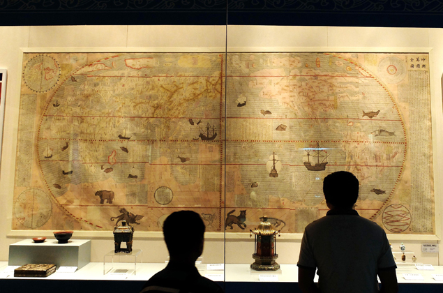 Visitantes observando uma reprodução de um mapa da dinastia Ming (1368-1644), durante exposição de antiguidades da rota marítima da seda, em Shandong