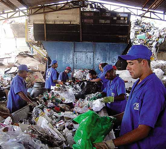 Homens trabalham com reciclagem de garrafas plsticas