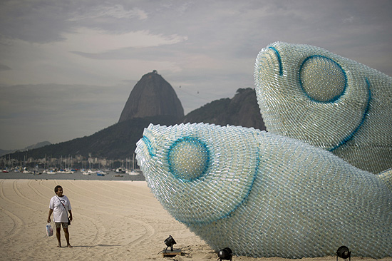 ORG XMIT: TOF415 A woman looks at an installation made of recycled plastic bottles representing fishes, in Botafogo beach, in Rio de Janeiro, on June 19, 2012, in the sidelines of the UN Conference on Sustainable Development, Rio+20. The UN conference, which marks the 20th anniversary of the Earth Summit -- a landmark 1992 gathering that opened the debate on the future of the planet and its resources -- is the largest ever organized, with 50,000 delegates. AFP PHOTO / Christophe Simon