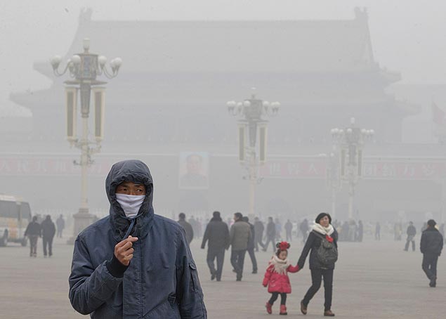 Homem usa máscara na praça Tiananmen em Pequim; acessório se tornou comum nas ruas das cidades mais poluídas do país