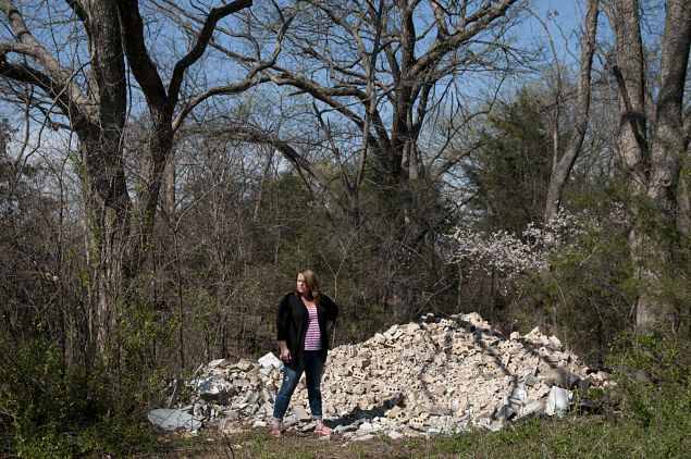 Jennifer Lin Cooper com uma pilha de tijolos que tiveram de ser retirados de sua casa depois de vrios terremotos