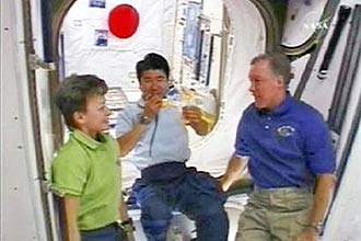 Astronauta Takao Doi (centro) segura um bumerangue, acompanhado de seus colegas na Estao Espacial Internacional