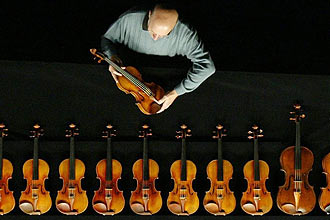 David Fulton, magnata norte-americano, examina um de seus violinos Stradivarius; colecionador tem vários instrumentos do século 18 