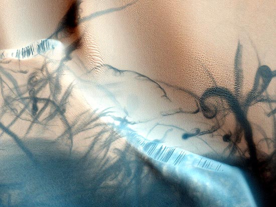 Imagem da sonda Mars Reconnaissance Orbiter mostra rastros de redemoinho de vento sobre terreno de Marte