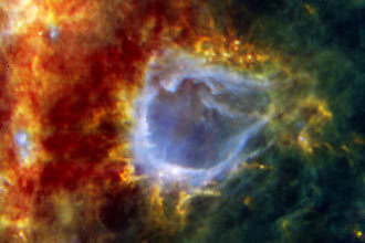 Imagem do telescópio europeu Herschel mostra a bolha galáctica RCW 120 (azul); embaixo na bolha, uma estrela em gestação. 