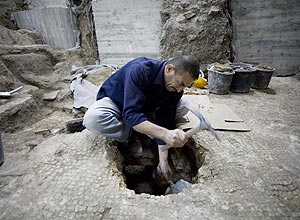 Homem trabalha em sítio arqueológico em Jerusalém, onde foi encontrada piscina usada por soldados de legião romana