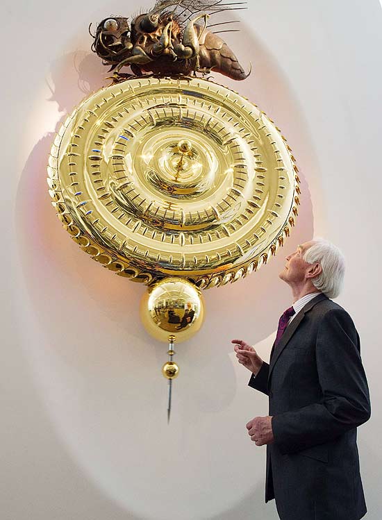 O inventor John Taylor ao lado de seu relógio que está exposto no Museu de Ciência em Londres