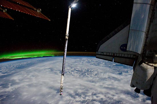 Luz verde da aurora austral pode ser vista à esquerda do Atlantis