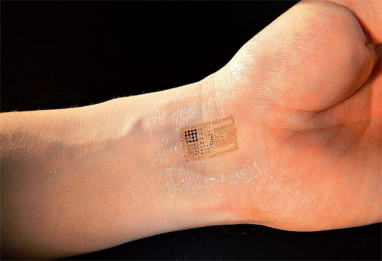 Adesivo com circuitos eletrônicos grudado no pulso de um voluntário; material fica naturalmente preso à pele 