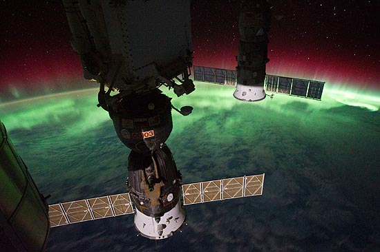 Na foto tirada por astronautas, aparece uma parte da estação espacial e a aurora austral ao fundo, em verde