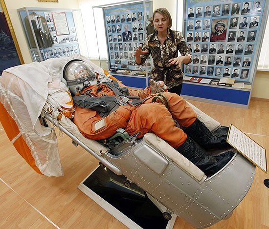 Funcionária de museu mostra a cadeira ejetável e o traje que foi usado pelo primeiro cosmonauta, Yuri Gagárin