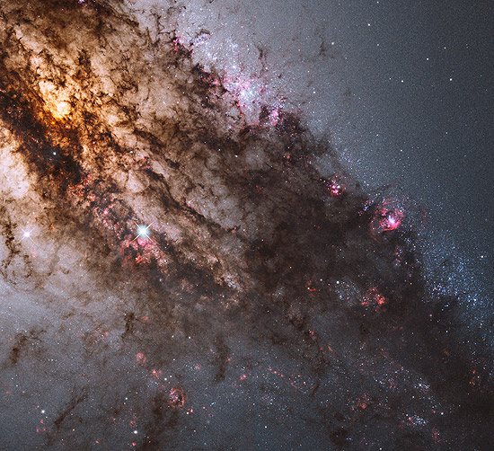 Os pontos vermelhos que aparecem na imagem são locais onde estrelas são formadas na galáxia Centaurus A
