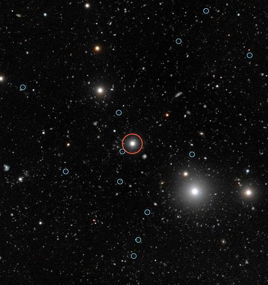 Imagem do Very Large Telescope modificada digitalmente mostra quasar (em vermelho) e galxias escuras (crculos menores)