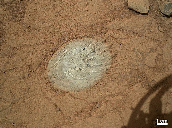 Imagem feita pelo próprio Curiosity mostra a área onde a poeira foi removida, que tem 47 mm por 62 mm