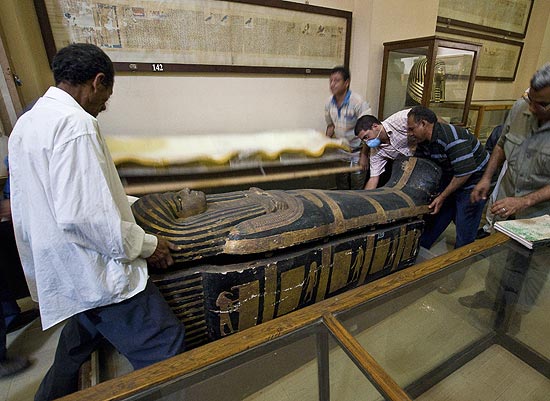 Múmia egípcia Hatiay sendo retornada ao seu sarcófago após ser submetida à tomografia na cidade do Cairo no Egito
