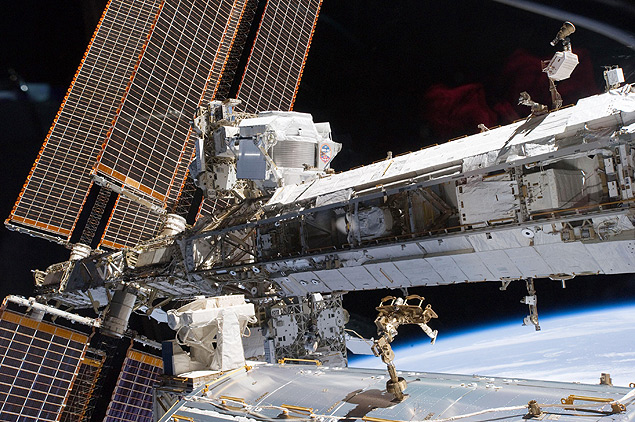 A Estação Espacial Internacional, em órbita da Terra, onde está o detector usado no experimento (no centro, acima) 