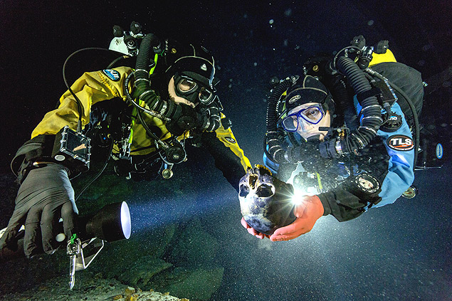 Mergulhadores seguram o crnio encontrado na caverna submersa de Hoyo Negro, na pennsula de Yucatn, no Mxico