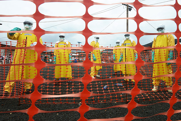 Trabalhadores de sade vestem roupas de proteo em rea contaminada de hospital de Monrvia, em setembro