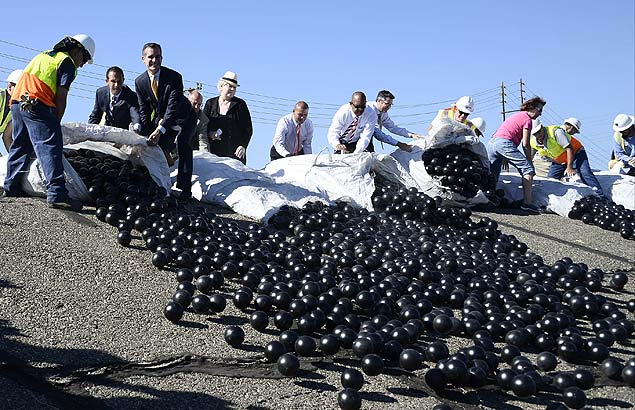 O prefeito de Los Angeles, Eric Garcetti e funcionrios despejam bolinhas de plstico sobre reservatrio da cidade