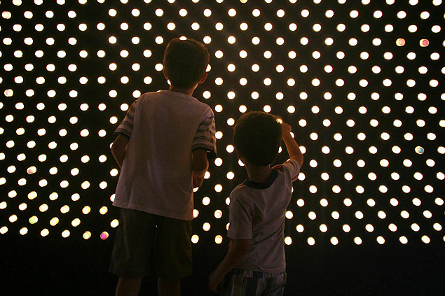 Crianas tocam painel iluminado na exposio da Unicamp em que o visitante pode brincar com cores