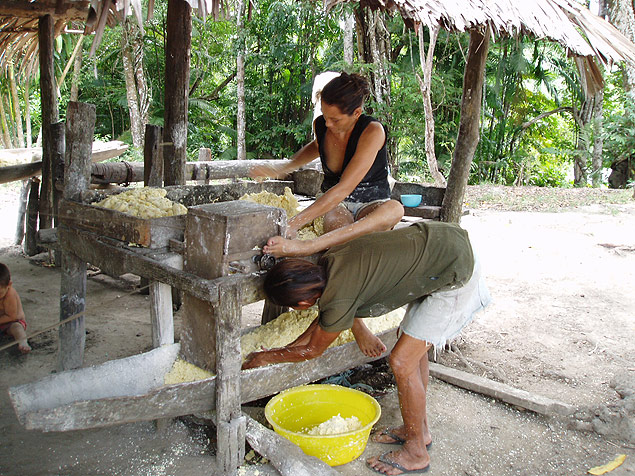 Homem e mulher durante processo de preparao da farinha de mandioca, em povoado ribeirinho do Par 