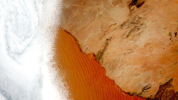 A cidade de Swakopmund est coberta por nuvens na imagem, mas as dunas do deserto da Nambia esto visveis. 