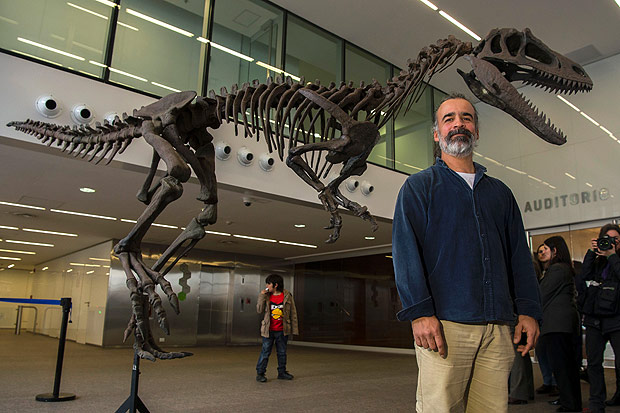 O paleontologista Sebastián Apesteguía posa perto da réplica de "Gualicho", o último dinossauro descoberto na Argentina